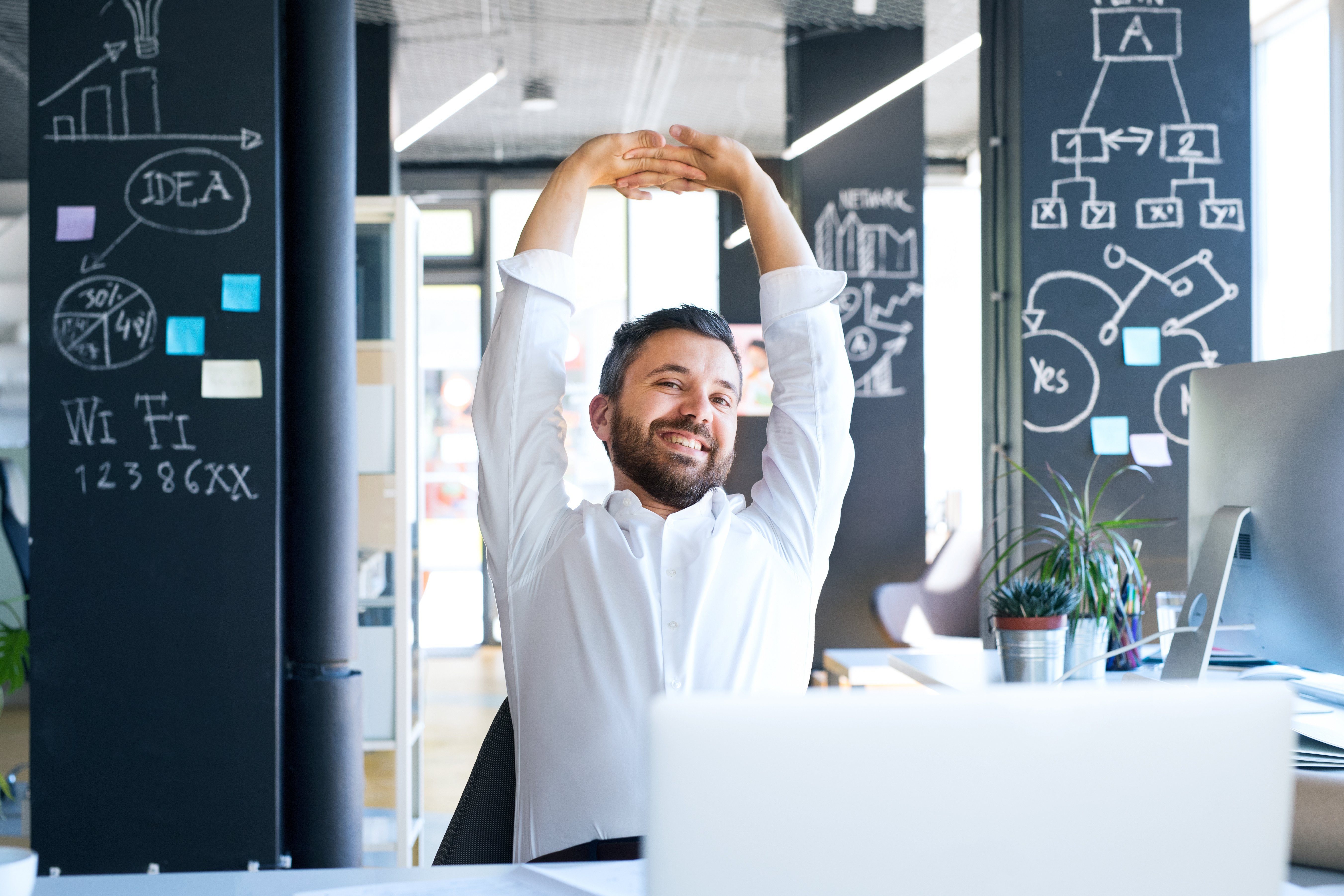 businessman-at-the-desk-in-his-office-stretching-a-2024-10-19-21-35-48-utc